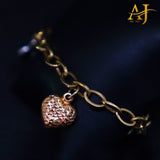 Pulsera con dije de corazón en tres tonos de oro de 14 kt